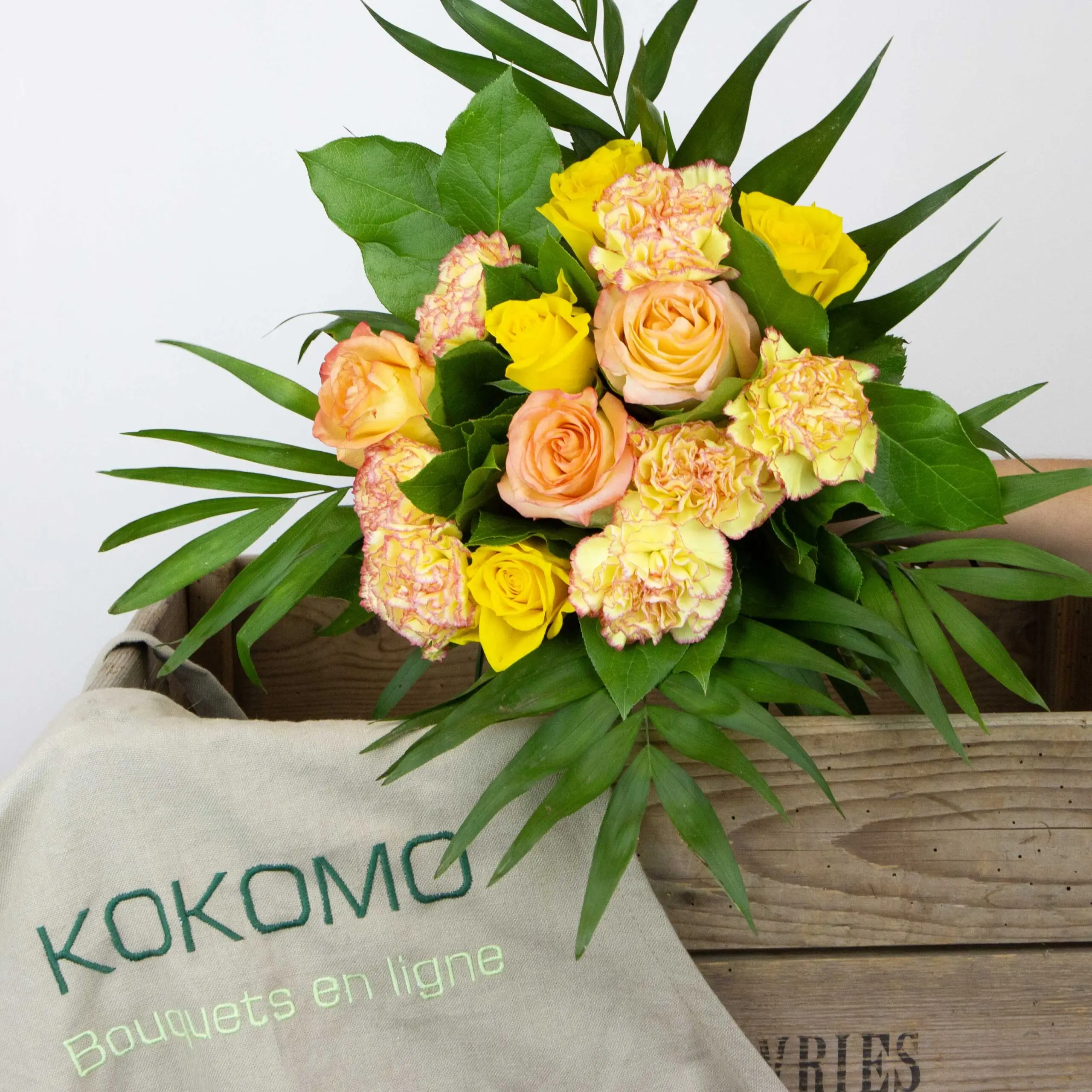 Bouquet Éclat de Soleil : roses oranges, roses jaunes, oeillets bicolore jaune/orangé, botte de sallal, chico