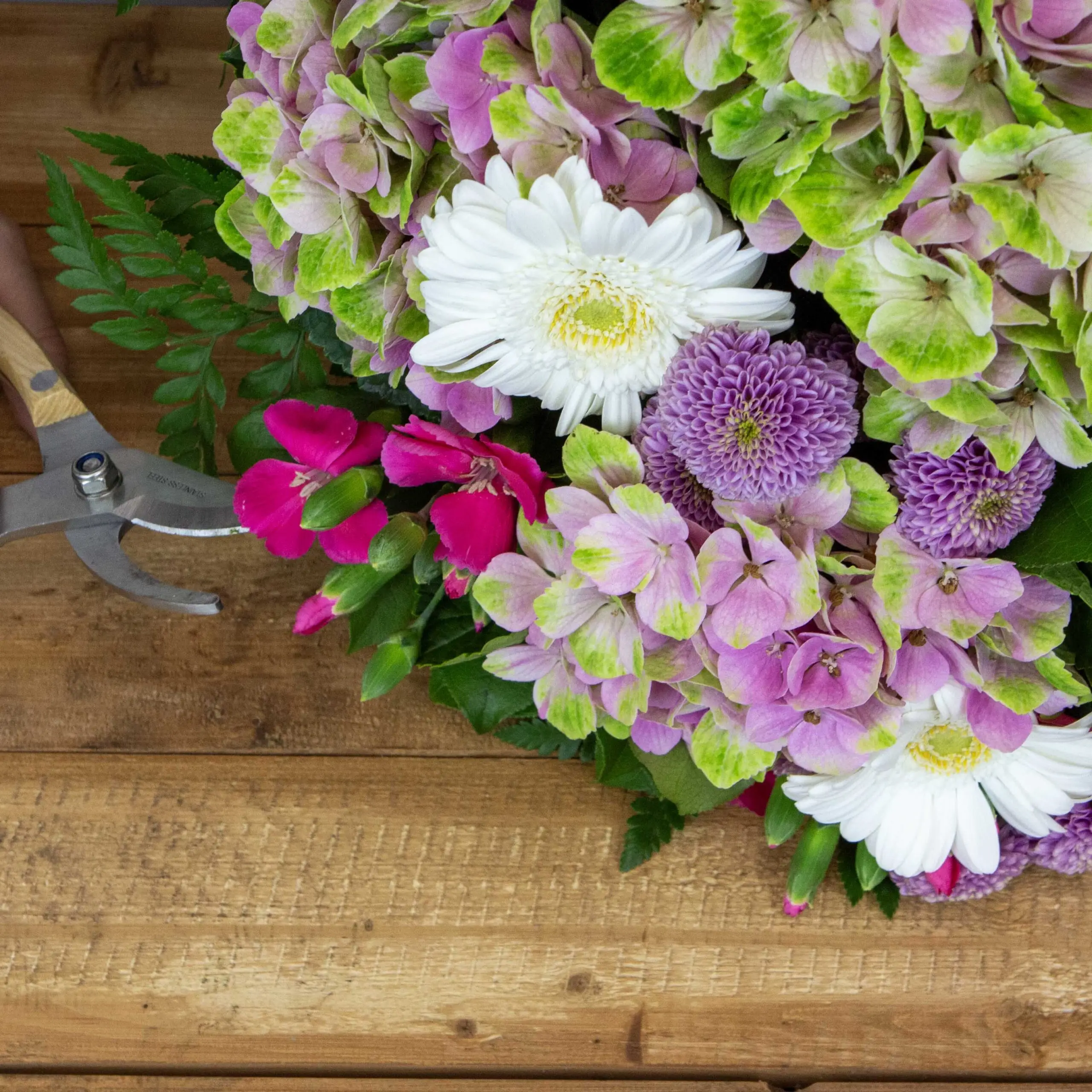 Bouquet Rosie : Hortensia rose vert, oeillets branchues, santinis roses, fougères