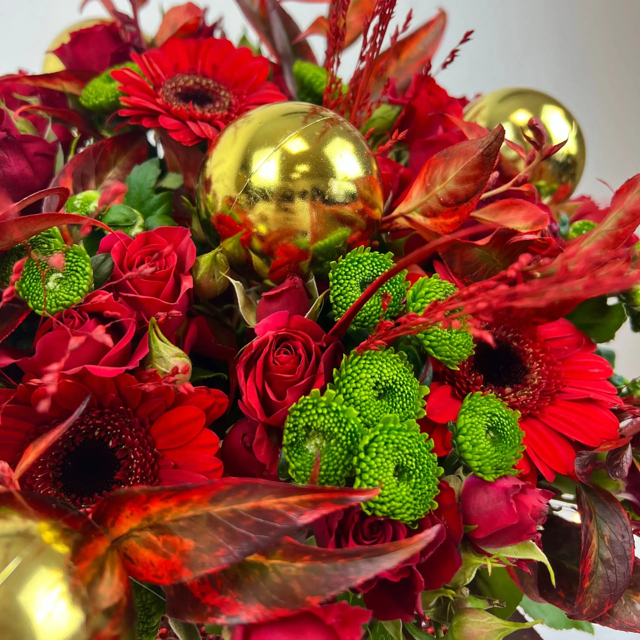 Bouquet de Noël 2024 aux couleurs chaleureuses rouges et dorés