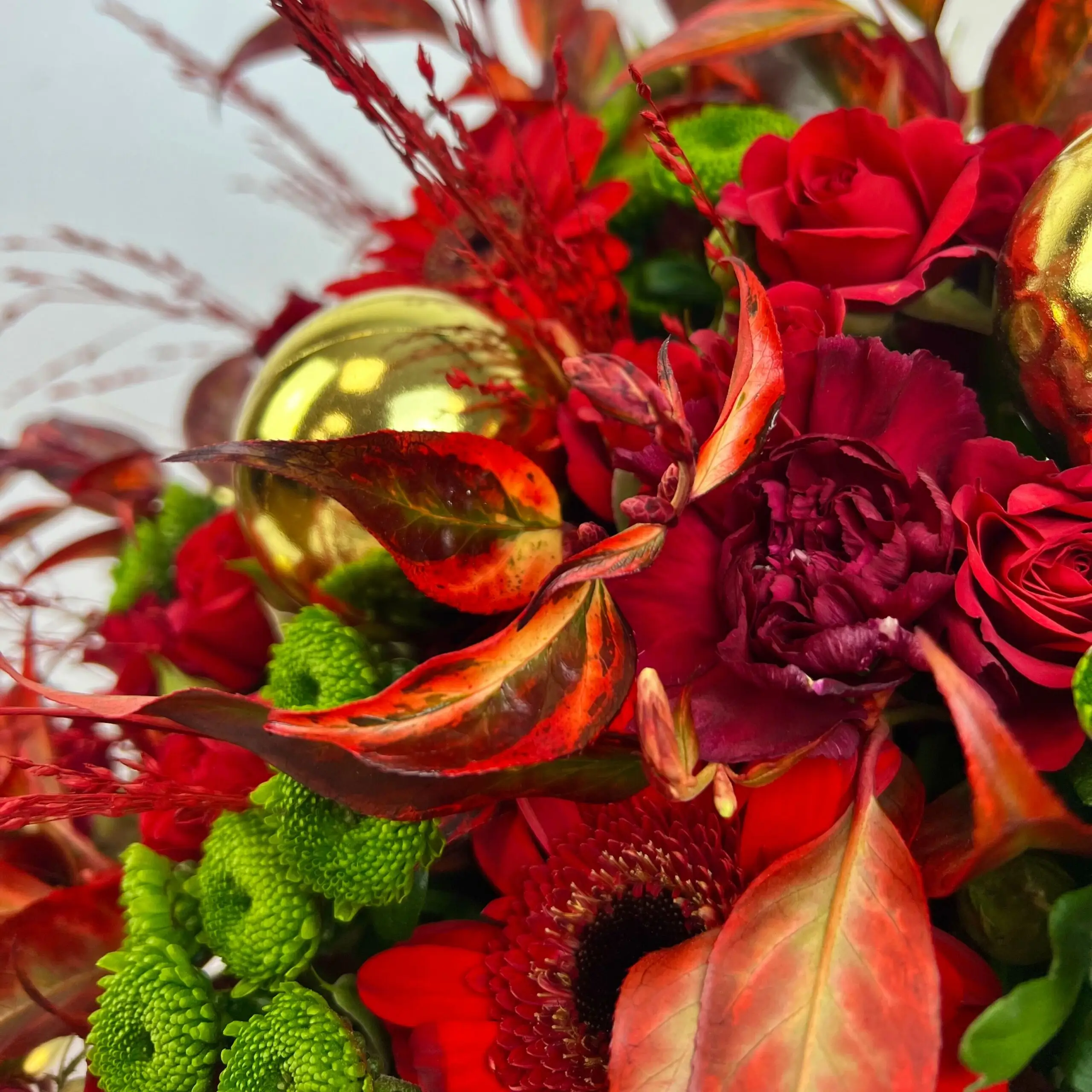 Bouquet de Noël 2024 aux couleurs chaleureuses rouges et dorés